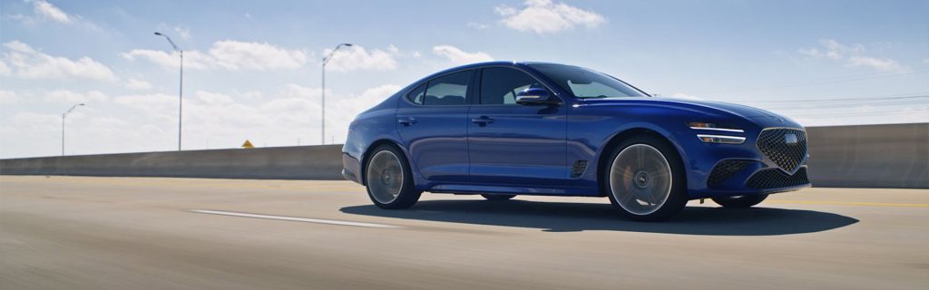 A 2026 Genesis G70 cruising along the highway, emphasizing its elegant lines and powerful presence.