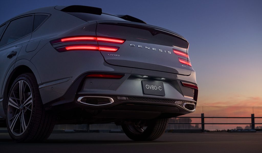 Rear view of a silver 2026 Genesis GV80 parked, showcasing its sleek design and distinctive tail lights.