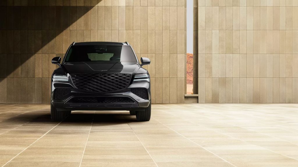 A black 2026 Genesis GV80 SUV parked in an elegant, modern space with beige stone walls and flooring.