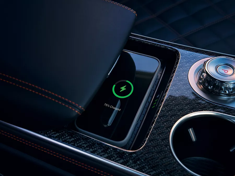 A wireless charging pad in a car with a phone indicating it is 75% charged.