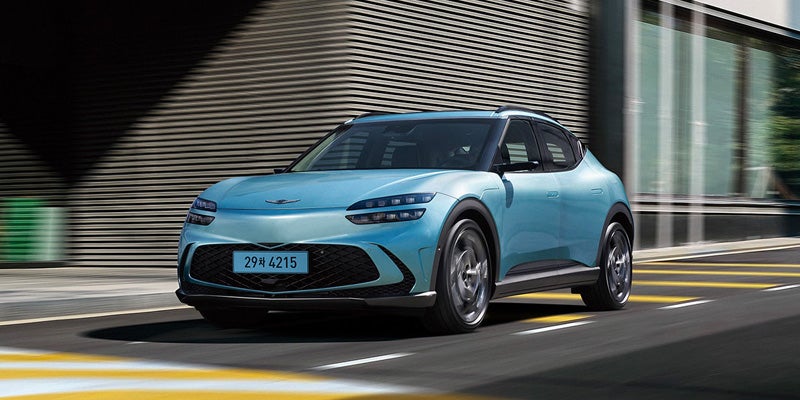 A Genesis GV60 electric SUV parked on a road.