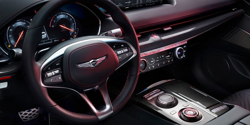 The interior, stearing of Genesis G70 is displayed.