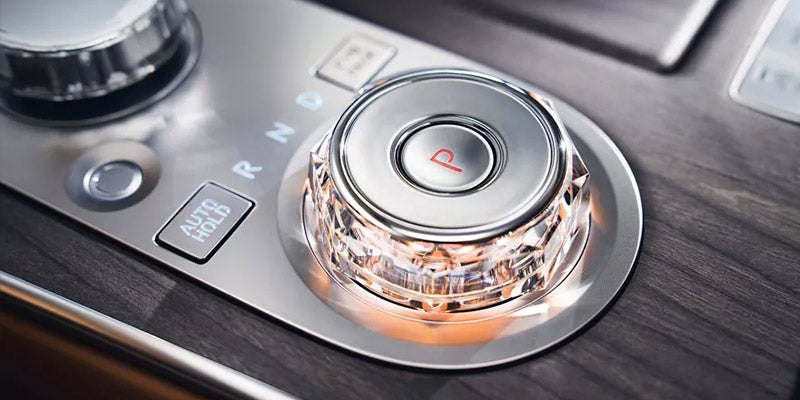 Close-up of a car gear selector with illuminated P button