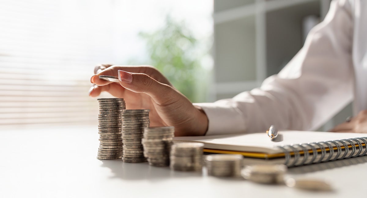 Man stacking rows of coins on a table