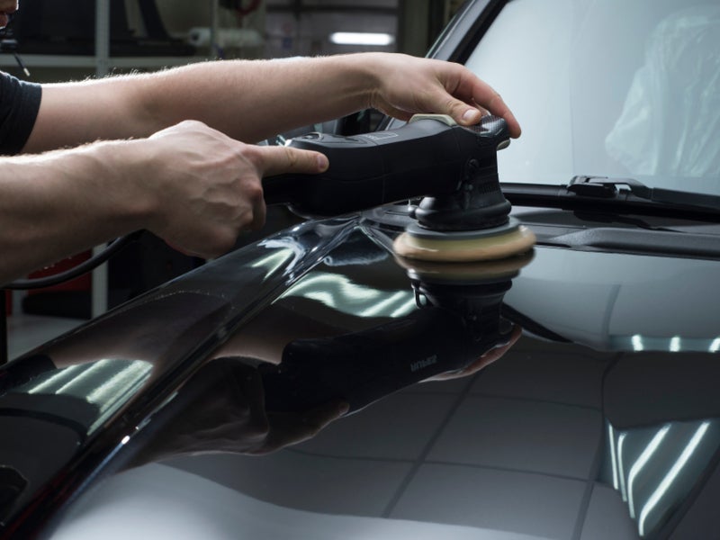 Technician servicing a car using a rolling machine