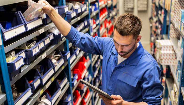 Worker managing inventory in warehouse